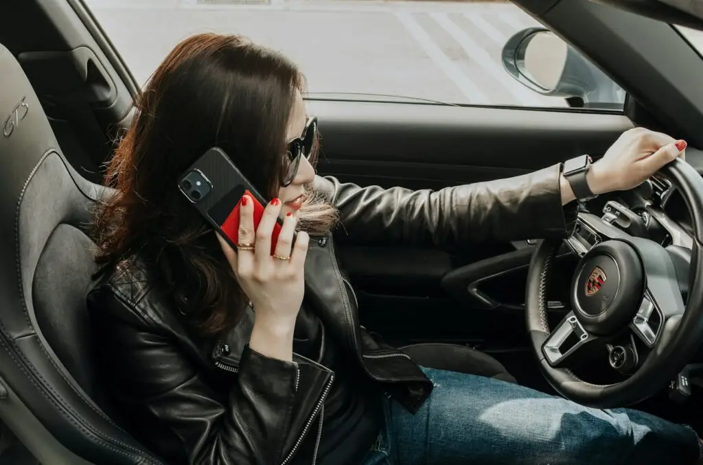 a woman sitting in a car talking on a cell phone